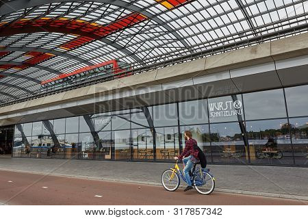 Cyclist Riding A Bike Along The Train Station In Amsterdam Netherlands