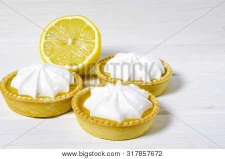 White Aircake With Lemon Filling And Lemon On A Wooden Table