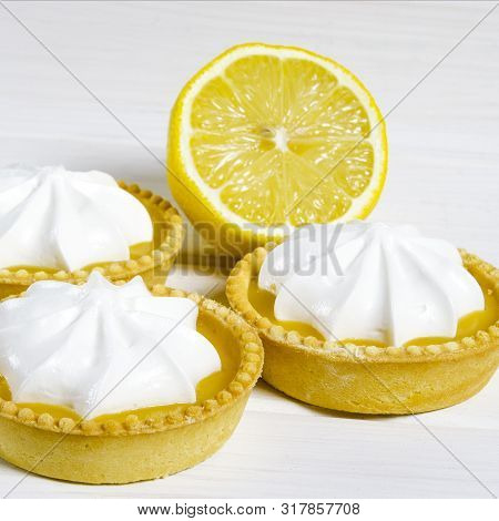 White Aircake With Lemon Filling And Lemon On A Wooden Table
