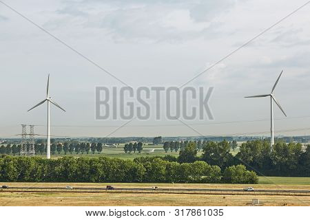 Windmills As Wind Turbine Power Generators Placed Within The Countryside Of Green Country Of Netherl