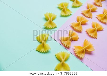 Italian Pasta Pattern On Pastel Colors Background. Various Colors Of Bow Tie Farfalle Pasta. Top Vie