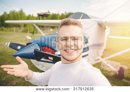 Happy Male Pilot Selfie Photo Aviator Smiling On Background Propeller Driven Aircraft. Travel Rental