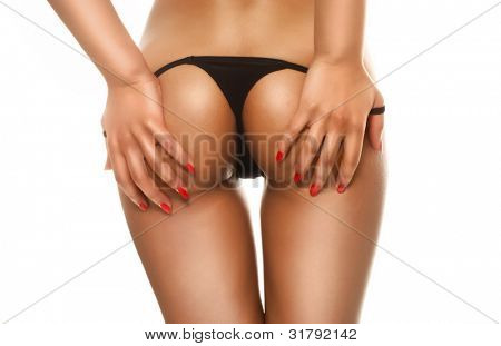 Ritagliate l'immagine delle mani femminile seducente accarezzando le natiche nude in un perizoma sexy nero
