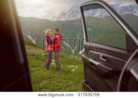 Happy Couple Hugs On Beautiful Nature And Mountains Out Of Car