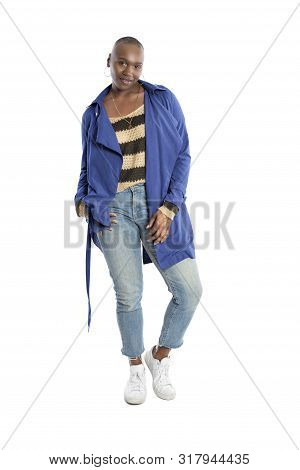 Black African American Fashion Model With Bald Hairstyle Confidently Posing With A Vibrant Blue Colo