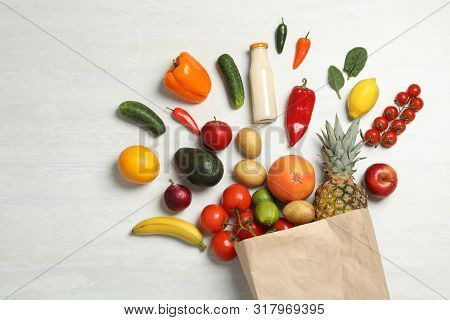 Shopping Paper Bag With Different Groceries On White Wooden Background, Flat Lay