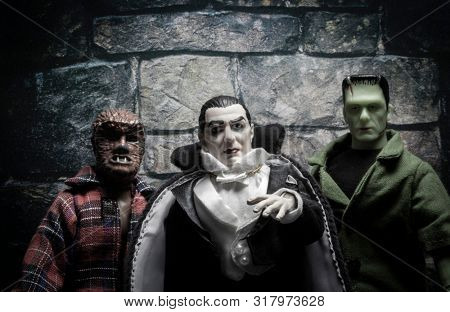 AUG 18 2019: Halloween concept of Frankenstein, Count Dracula and Werewolf - vintage retro movie poster look - Mego Corporation action figures