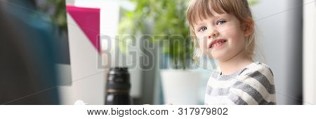 Cute Little Girl Sitting At Home At Worktable Looking In Camera Portrait