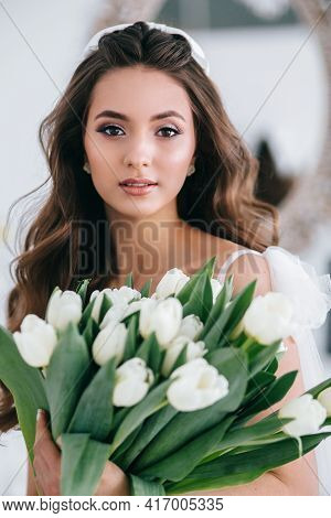 Beautiful Bride Holding Wedding Bouquet Of White Tulips In Her Hands In Studio. Wediing Day