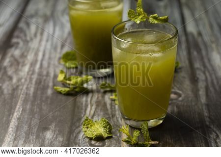 Selective Focus On Glass Of Mint Leaves Juices On Wooden Table