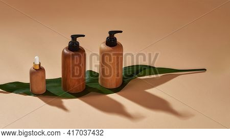 Closeup Of Wooden Bottles Of Different Sizes On Green Leaf Isolated On Beige Background. Zero Waste 