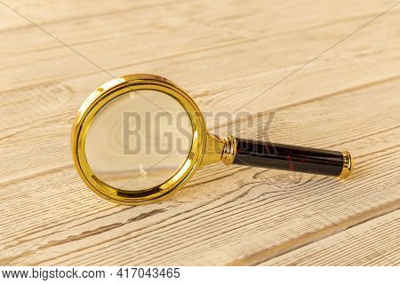 A Magnifying Glass On A Wooden Table. The Concept Of Information Search. Selective Focus