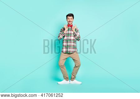 Photo Of Attractive Guy Hands Hold Bowtie Toothy Smile Wear Plaid Shirt Pants Shoes Isolated Blue Co