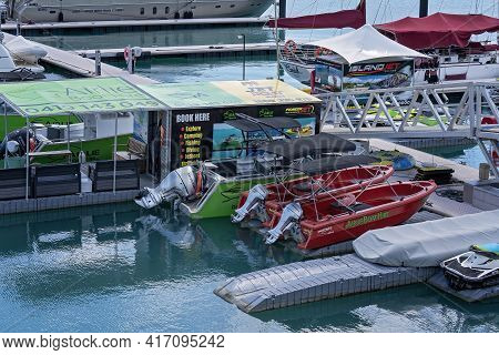 Airlie Beach, Queensland, Australia - April 2021: Water Sports Booking Office And Tourist Boats For 