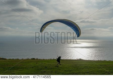 Man Doing Sport, Para-glider In The Clouded Sky. Paragliding Is An Extreme Sport And Recreation. Tor