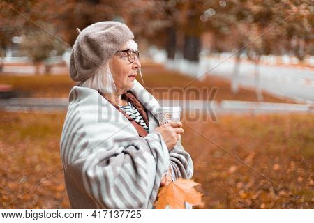 A Lady In A Warm Wool Blanket Holds A Paper Cup Of Hot Tea Or Coffee Drink While Enjoying The Beauti