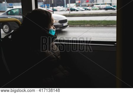 A Girl In A Mask Sits On The Bus, Looks Out The Window, In The Dark, Lifestyle During A Pandemic, Qu