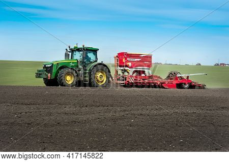 Baykivtsi, Ternopol Region, Ukraine - April 10, 2021: Farmers Sow, Apply Fertilizers Using A John De