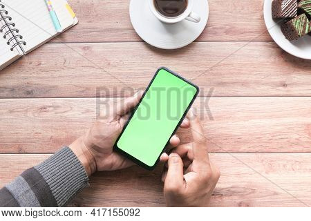 Top View Of Man Hand Using Smart Phone On Office Desk