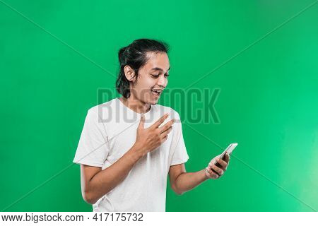 Portrait Man Holding And Look Handphone With Shocked Happiness Expression While Raising One Hand