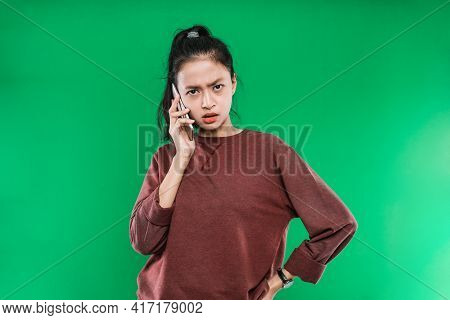 Beautiful Young Asian Woman Talking On Phone With Angry Expression