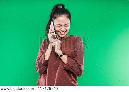 Young Woman Is Talking On The Phone Laughing Happily With Someone
