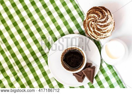 Dark Chocolate And Cocoa Chocolate Cupcakes With A Cup Of Hot Black Coffee On Green Napkin. Space Fo