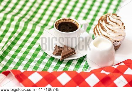 Dark Chocolate And Cocoa Chocolate Cupcakes With A Cup Of Hot Black Coffee On Green And Red Napkin.