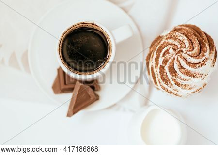 Dark Chocolate And Cocoa Chocolate Cupcakes With A Cup Of Hot Black Coffee On Green Napkin. Space Fo