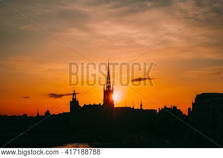 Stockholm, Sweden. Sunset Sun Shine Through Dark Silhouette Of Riddarholm Church In Stockholm Skylin