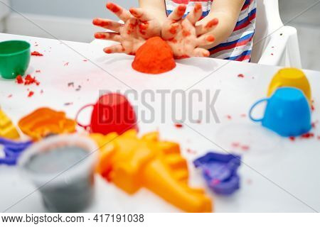 A Childs Hands Play With Bright Kinetic Sand On A White Table. An Educational Game Of Kinetic Sand W
