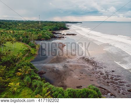 Aerial View Of Black Sand Beach, Ocean And Waves In Balian, Bali Isalnd