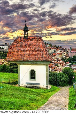 St. Jost Chapel In Fribourg, Switzerland At Sunset