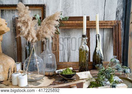 Bottles In Like Candlestick In Molten Wax, Dry Flowers On Table In Creative Room