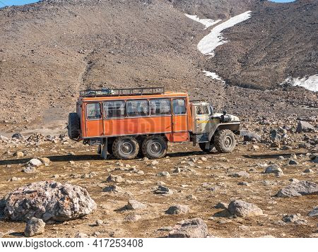 View Of The Mountain Range Near The Mutnovsky Volcano. Large Passenger Kamaz Brought Tourists To Cli