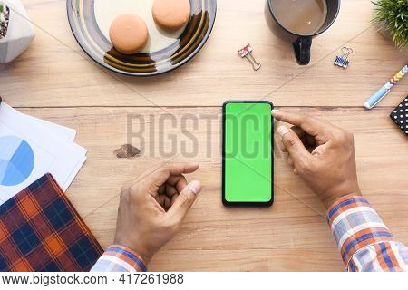 Top View Of Man Hand Using Smart Phone On Office Desk