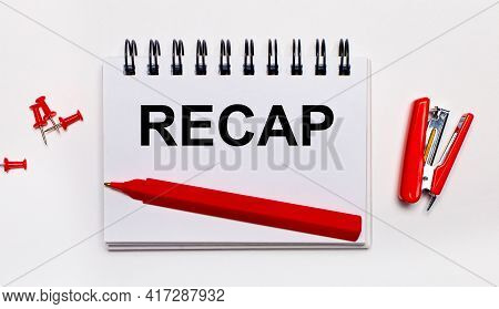 On A Light Background, A Red Pen, A Red Stapler, Red Paper Clips And A Notebook With The Inscription