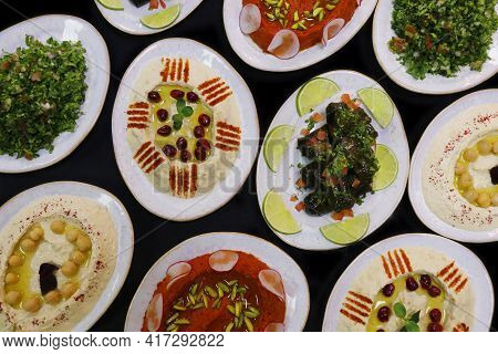 Selection Of Libanese Food Mezze, Includes Hummus, Muhammara, Moutabal, Taboule And Vine Leaves