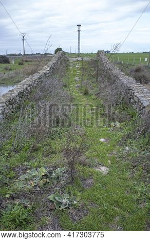 Medieval Bridge Of Santiago De Bencaliz Near The Village Of Aldea Del Cano, Caceres, Spain. This Is 