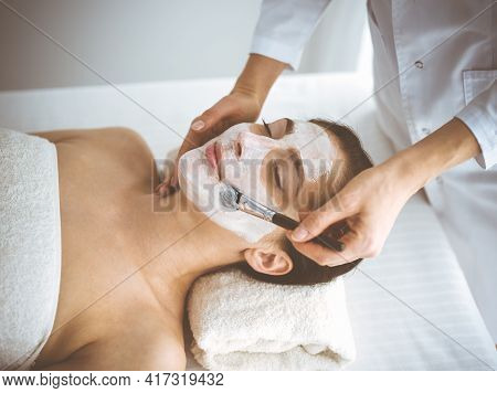 Beautiful Brunette Woman Enjoying Applying Cosmetic Mask With Closed Eyes Comfortable And Blissful. 