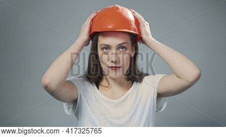 Photo Of Woman Wearing Orange Helmet On Grey