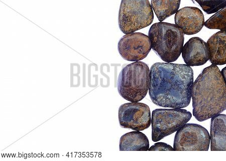 Bronzite Heap Jewel Stones Texture On Half White Light Isolated Background. Place For Text.