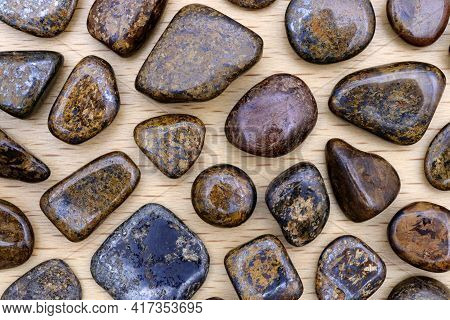 Bronzite Rare Jewel Stones Texture On Light Varnished Wood Background