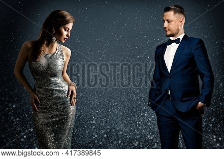 Fashion Luxury Couple. Glamour Woman And Handsome Man. Elegant Pair In Evening Dress And Suit. Spark
