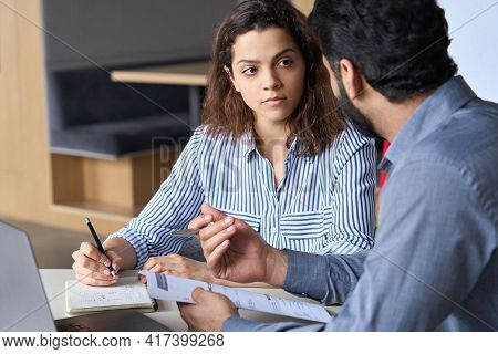 Mentoring Young Male Hispanic Teacher And Latin Indian Female Student Working Together Discussing Co