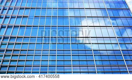 Abstract Closeup Of The Glass-clad Facade Of A Modern Building Covered In Reflective Plate Glass. Ar