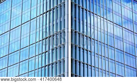 Abstract Closeup Of The Glass-clad Facade Of A Modern Building Covered In Reflective Plate Glass. Ar
