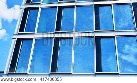 Abstract Closeup Of The Glass-clad Facade Of A Modern Building Covered In Reflective Plate Glass. Ar