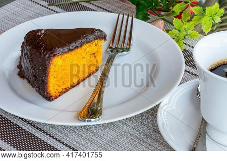 Carrot Cake With Chocolate Icing, Accompanied By A Cup Of Coffee