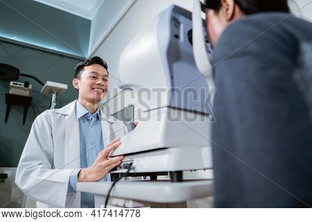 A Male Doctor And A Female Patient Doing An Eye Check Using A Device